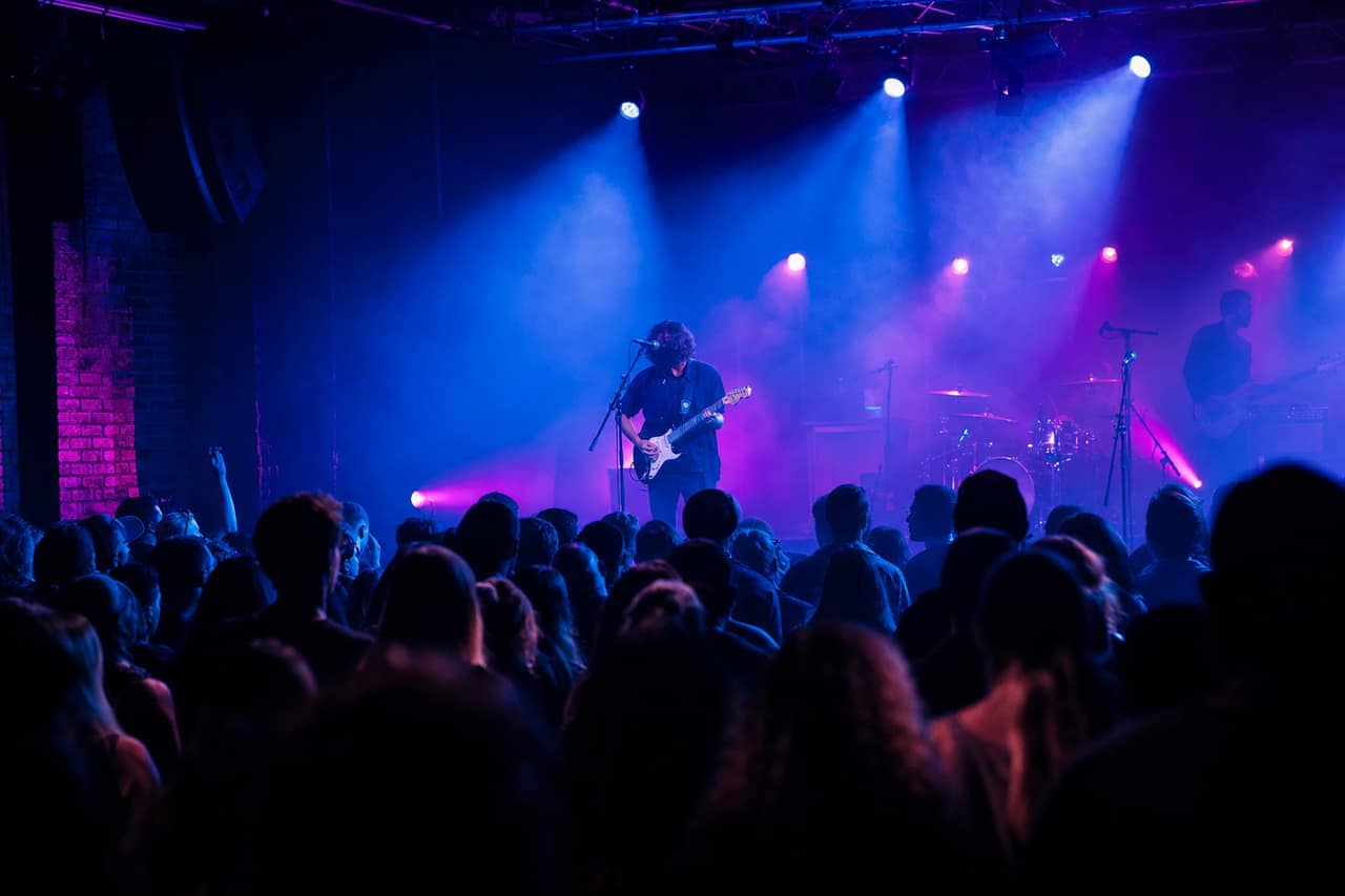 A concert crowd in front of a lit stage